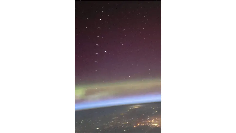 A View Beyond Earth: Astronaut Captures SpaceX Starlink Train Gliding Over Dance Auroras